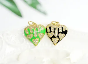 Detailed macro view of heart charms with drip glaze and 18K gold plating with zircons