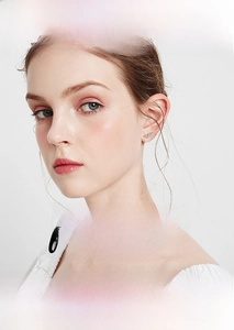 Close-up of elegant S925 sterling silver pea-shaped earring with moissanite on ear