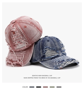 Close-up of distressed denim baseball caps with vintage ripped details in pink and blue
