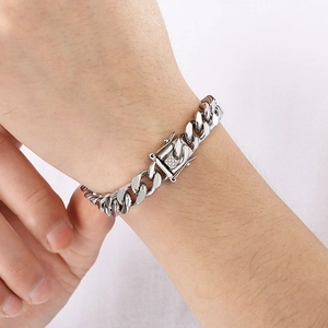 Close-up of a silver stainless steel Cuban link bracelet worn on a male wrist