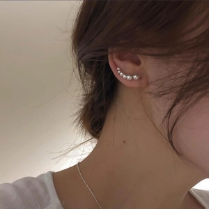 Detail of minimalist S925 silver ear cuff featuring five graduated white pearls in a curve