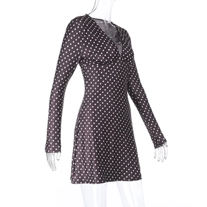 Detail view of V-neck long sleeve dress with white polka dots on a dark brown fabric