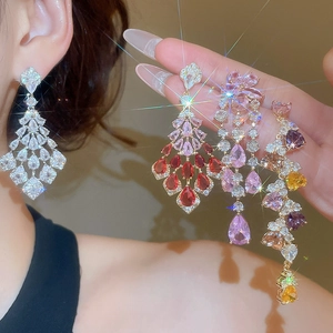 Macro detail of luxurious silver earrings with heart zircon and sparkling long tassels