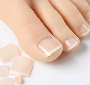 Vue détaillée des faux ongles de pieds French manucure classiques blancs sur base nude rose
