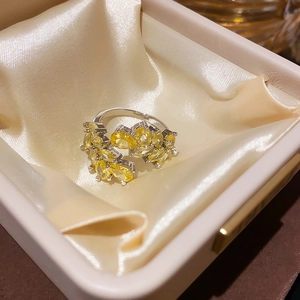 Close-up of elegant flower ring with yellow oval gemstone in a jewelry gift box