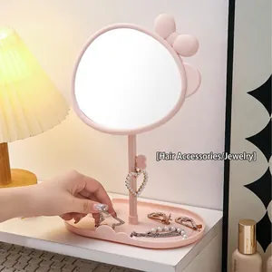 Pink bow makeup mirror with rotating oval glass and functional jewelry storage tray