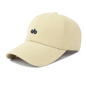 Macro detail of the embroidered blue letters ab on the cream cotton baseball cap