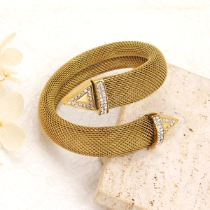 Macro detail of a 18K gold mesh open cuff bracelet with sparkling crystal triangle ends