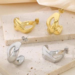 Detail view of 18k gold and silver irregular C-shaped twisted titanium steel earrings