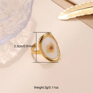 Detail shot of a 2.3cm golden open ring featuring a yellow dried flower in white resin