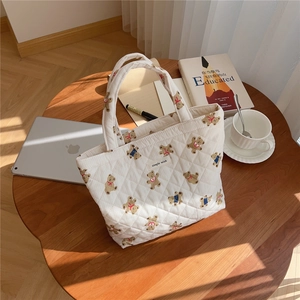 Detailed shot of quilted cotton handbag with bear print on a cozy wooden table