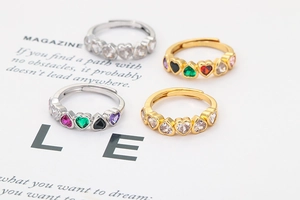 Close-up of adjustable heart-shaped rings with colorful zircon stones in gold and silver