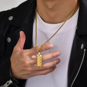 Detail of men gold stainless steel necklace with geometric tire pattern on male model