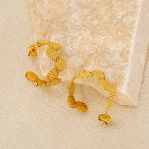 Chic golden geometric textured hoop earrings displayed on a natural stone surface