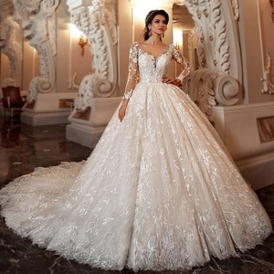 Elegante witte kanten trouwjurk met lange mouwen, een volle rok en een luxe lange sleep