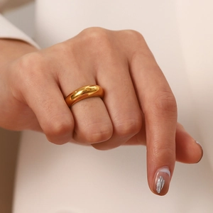 Close-up of minimalist 18K gold plated stainless steel domed ring worn on finger