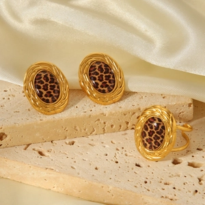 Macro view of vintage 18k gold oval earrings and ring with leopard print details