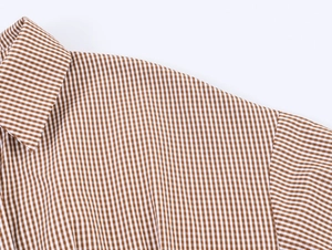 Detailaufnahme von Kragen und Schulternaht des braun-weiß karierten Hemdes aus Webstoff