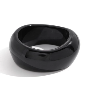 Dettaglio del bracciale largo in resina nera irregolare con finitura lucida a specchio
