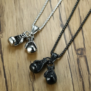 Detail of silver and matte black boxing glove pendants on rustic wood surface