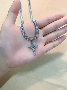 Macro shot of silver cross pendant with shimmering cubic zirconia and square-cut stones