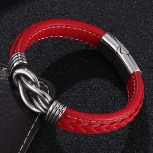 Close-up of red braided leather bracelet with silver magnetic clasp and metal knot detail