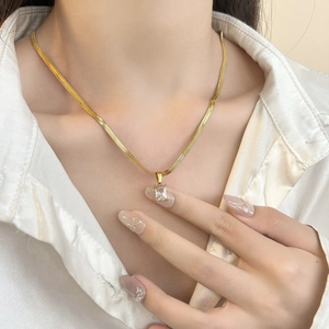 Elegant gold snake chain necklace with square green zircon pendant worn by model