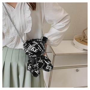 Detail of black bear crossbody bag with white graffiti art and silver chain strap