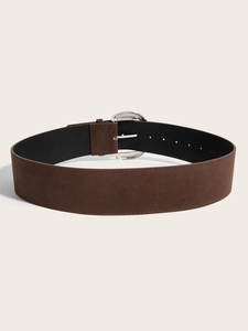 Detail of dark brown suede wide belt featuring a textured silver round metal buckle