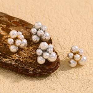 Detailed shot of multi-size white pearl cluster earrings with 18K gold plated base