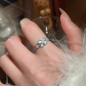 Detailed view of an elegant zircon flower open ring on finger with sparkling stones