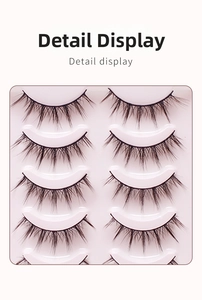 Detail view of five pairs of natural cross-style synthetic false eyelashes in a white tray