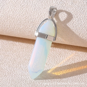 Macro view of a hexagonal opal pendant with rainbow prism reflections on a textured base