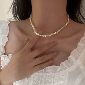 Detail of baroque freshwater pearl necklace on neck showing natural luster and texture