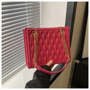Close-up of pink quilted crossbody bag with luxury gold chain strap and diamond texture