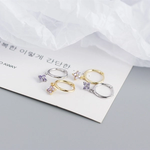 Detailed macro view of S925 silver flower earrings with purple zircons and secure clasp