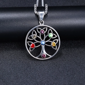 Macro detail of silver Tree of Life pendant with seven colorful rhinestones on chain