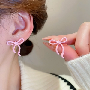 Detailed view of sweet pink bow earrings showing model wear and material finish