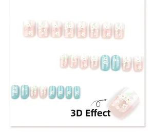 Detail showing 3D embossed flowers and blue glitter on white gradient fake nails