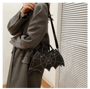 Close-up of black bat-shaped PU leather handbag with white spider web embroidery detail