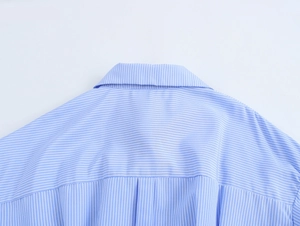 Close-up of blue and white striped shirt collar and back yoke detail on cotton fabric