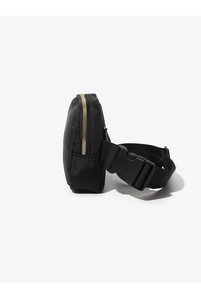 Detail view of black nylon waist bag featuring gold zipper and adjustable buckle strap