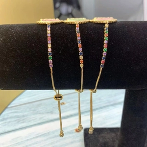 Detailed macro view of three adjustable gold bracelets with vibrant multicolor crystals