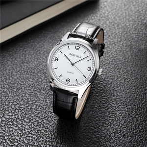 Detailed close-up of polished silver quartz watch with white dial and black leather strap