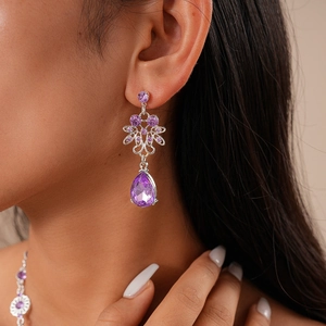 Detail of luxury teardrop earring with purple crystals and vintage flower design on model