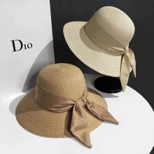 Detail of wide-brimmed straw hats with elegant silk ribbons and decorative bows