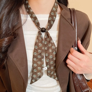 Detail of a brown floral chiffon scarf necklace with a round decorative buckle