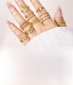 Detailed view of layered gold titanium steel rings with leaf and wave patterns