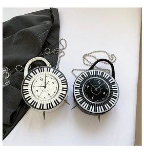 Detail view of round piano and clock pattern handbags with metal spikes and chain