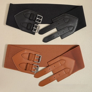 Close-up of black and brown elastic wide belts with decorative double pin buckles